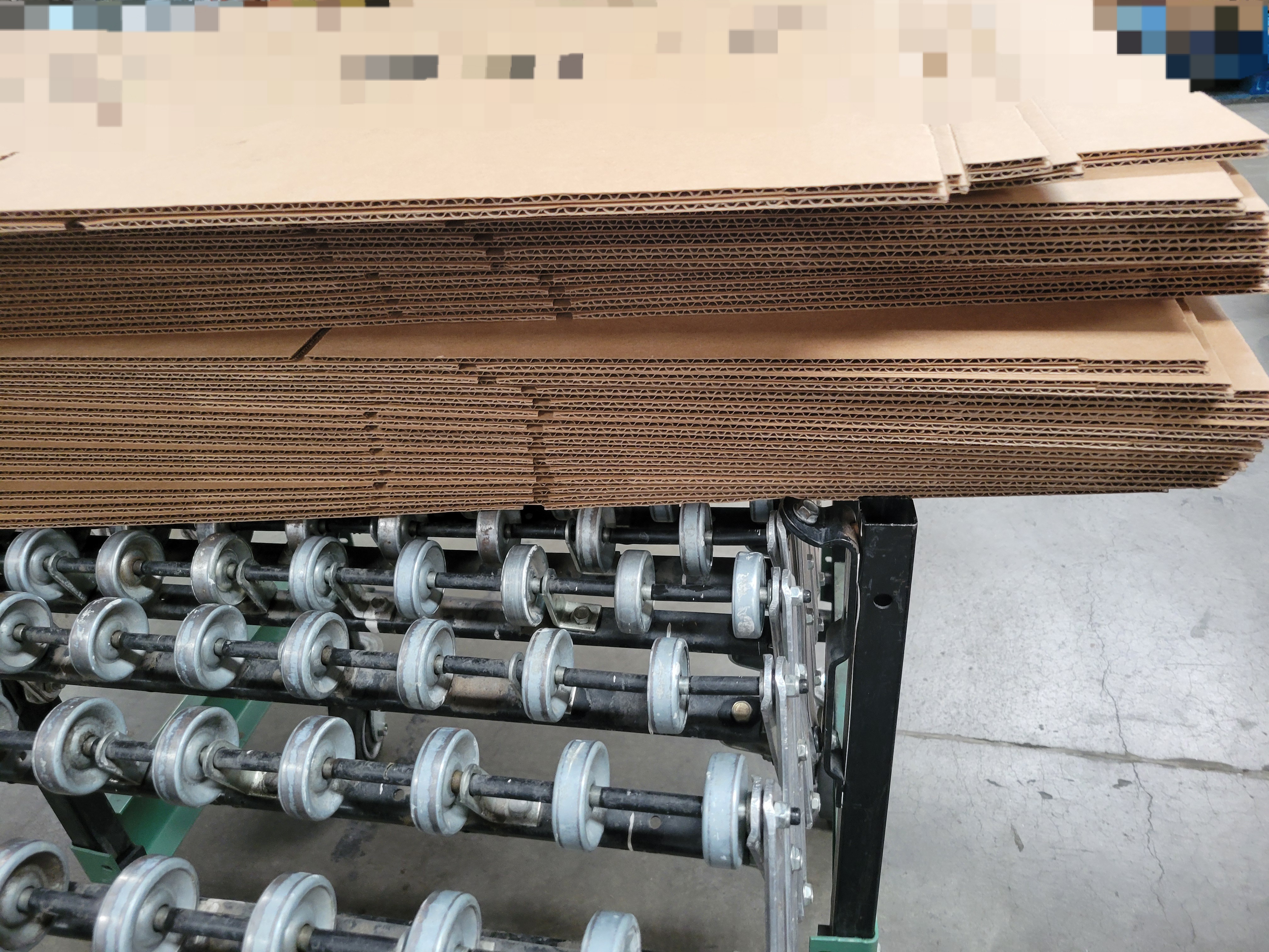 Unmade cardboard boxes on a conveyor belt.